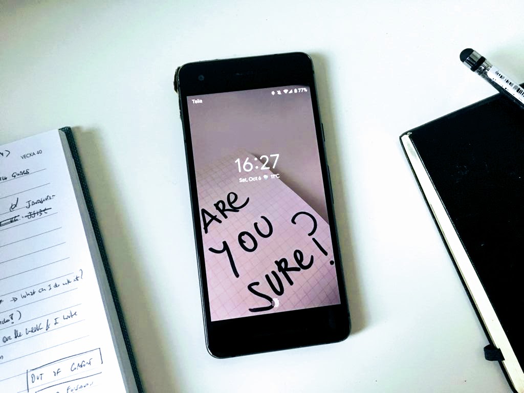 Image of a smartphone with a lock screen wallpaper displaying the message 'Are you sure?'