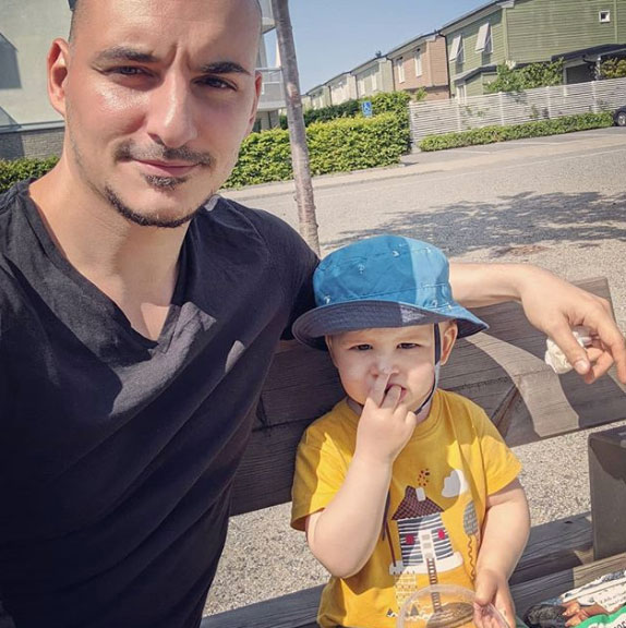 Jaime and Teo on a bench eating oranges under the sun