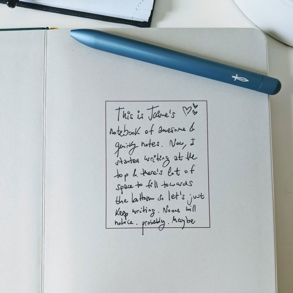 My notebook! The first page of a baronfig notebook and a blue pen. There's a note that says: This is Jaime's notebook of awesome and quirky notes.