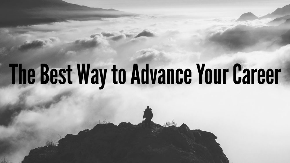 The Best Way to Advance Your Career person standing in the top of a mountain