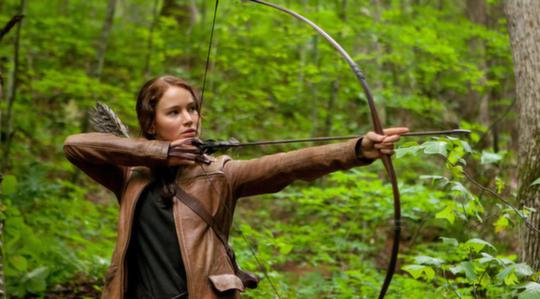 The Hunger Games Katniss aiming with her bow in the forest outside district 12